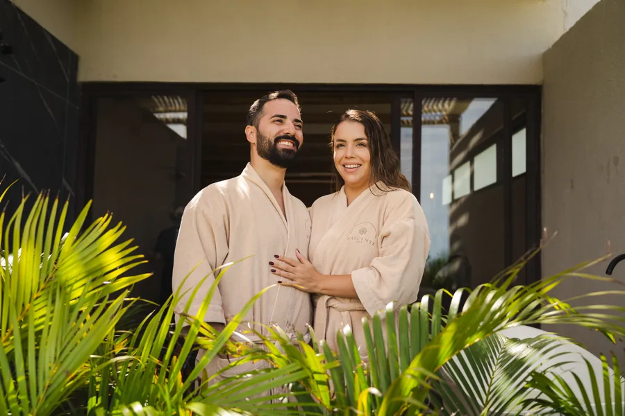 Casal de roupões no jardim do spa do resort