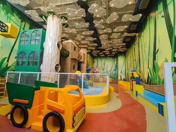 Espaço Kids do Pepito: área coberta com cenário de floresta, casa na árvore e caminhão de brincar