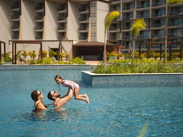 Mãe e filho brincando em uma das piscinas externas do resort
