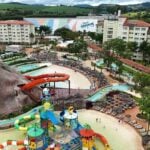 Imagem mostra a Ilha Tauá em primeiro plano o aquapark indoor em ultimo e ao redor os prédios de apartamento do Tauá Resort Atibaia.