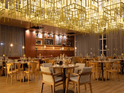restaurante italiano exclusivo do Tauá ornamentado com luminárias contemporâneas douradas, espaço amplo com bar.