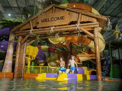 Vista da casinha que abriga um dos toboáguas no Tauá Aquapark Indoor, chão coberto de água.